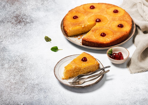 Piece of upside down pineapple cake with candied cherries and caramel