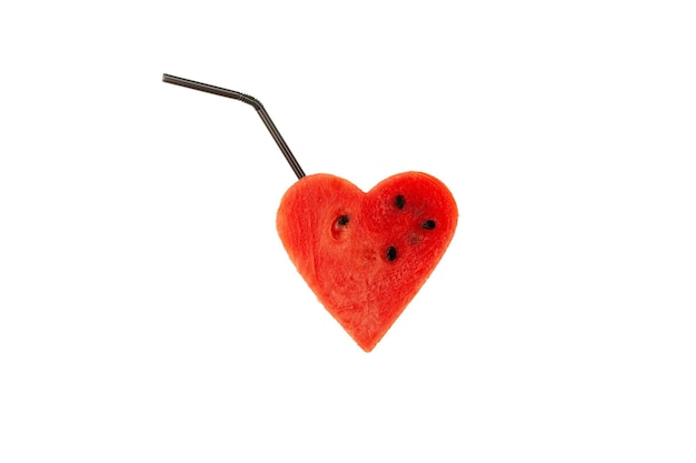 Piece of watermelon in the shape of heart with straw Concept refreshing drinks watermelon pulp