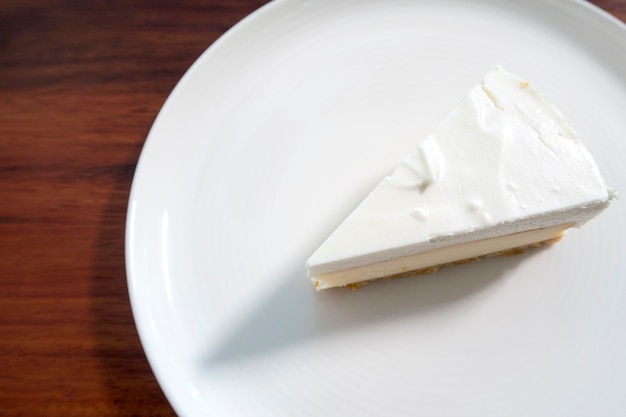 a piece of white cake on white dish. top view.