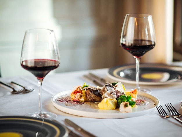 Pieces of beef meat steaks with different sauces and red wine