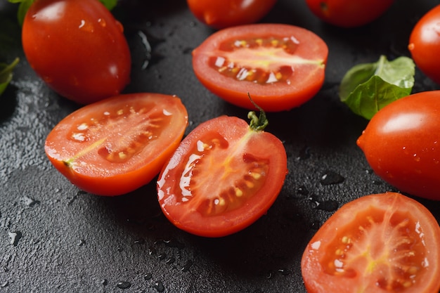 Pieces of cut fresh tomatoes over dark background