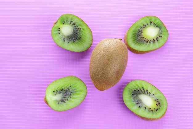 Pieces of fresh kiwi fruit on color background. Kiwi on purple background