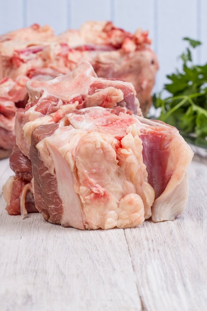 Pieces of fresh raw veal tail on wooden background.