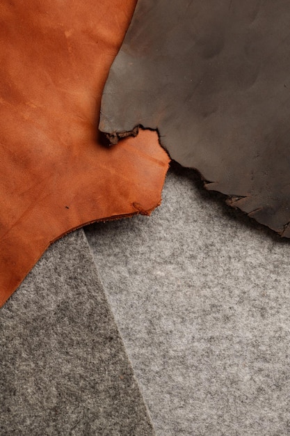 Pieces of genuine leather and felt on a wooden table Top view The concept of handmade leather goods Copy space