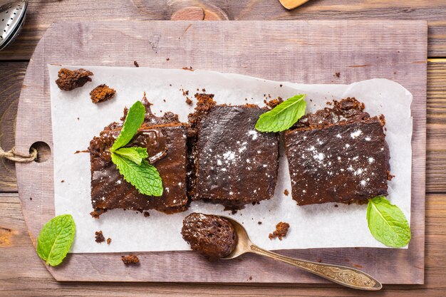 Pieces of homemade chocolate brownies with leaves of mint