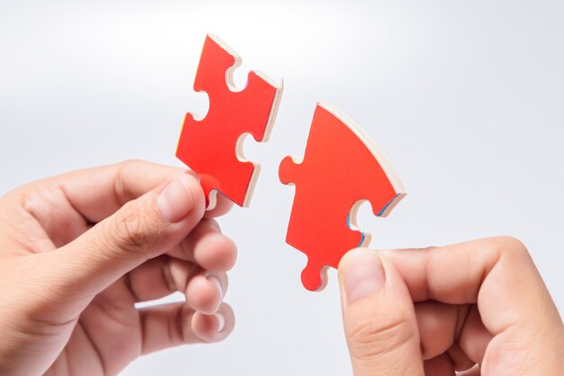 Pieces of jigsaw puzzle in woman's hands