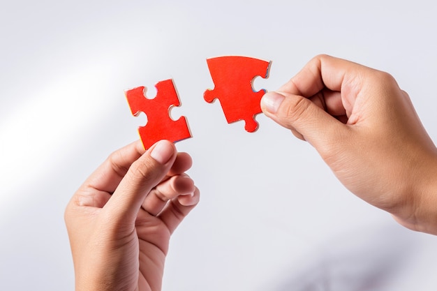 Pieces of jigsaw puzzle in woman's hands