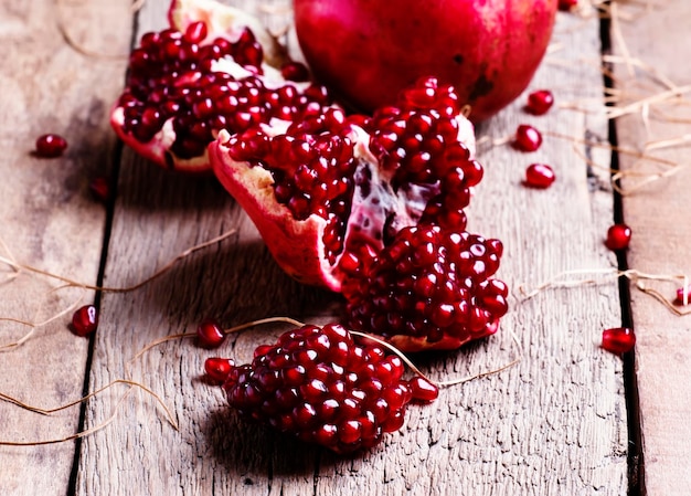 Pieces of pomegranate rustic style old wooden background selective focus