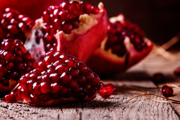 Pieces of pomegranate rustic style old wooden background selective focus