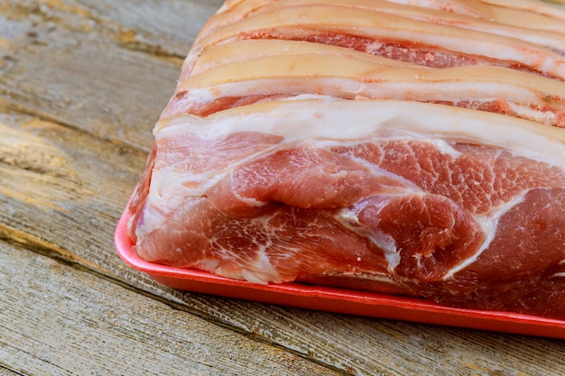 Pieces of raw pork steak with wooden background in rustic style