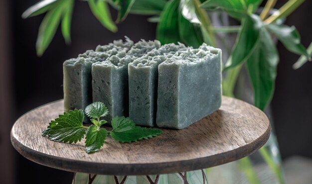 Pieces of refreshing natural handmade soap on a wooden stand with green leaves of fresh mint Concept of organic cosmetics for skin care