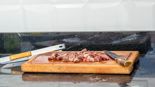 pieces of roast beef cut on a wooden board, traditional brazilian barbecue