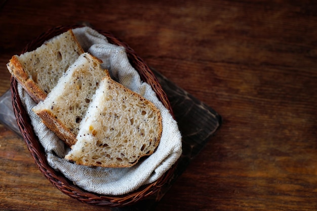 Pieces of sliced bread lie in a wicker basket on a wooden table Fresh homemade baking of yeastfree bread with your own hands