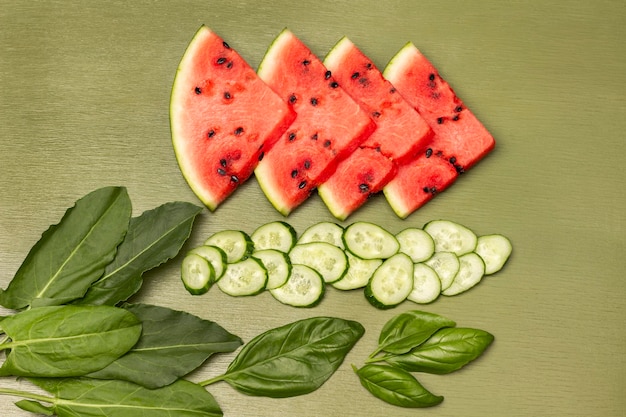 Pieces of watermelon chopped cucumber and basil leaves