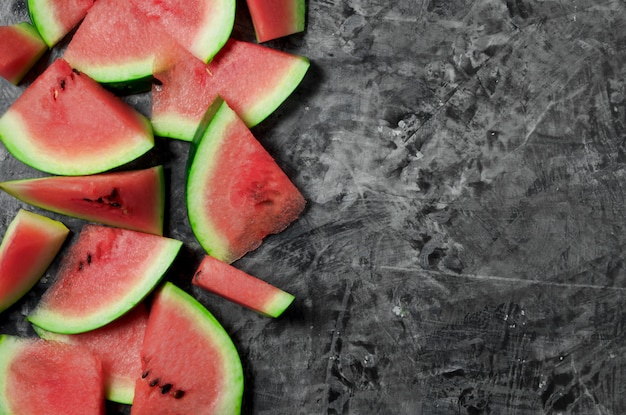 Pieces of watermelon. Sliced juicy watermelon on a gray concrete surface. View from above. copyspace.