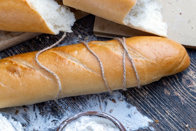 Pieces of wheat baguette on a cutting board pieces of wheat baguette with raw dry cereals and barley