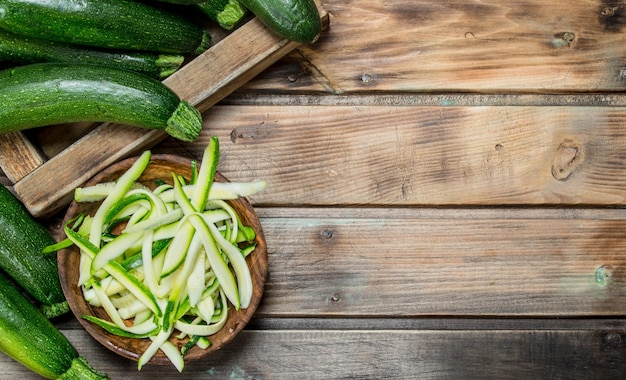 Pieces of zucchini in a bowl and whole zucchini tray