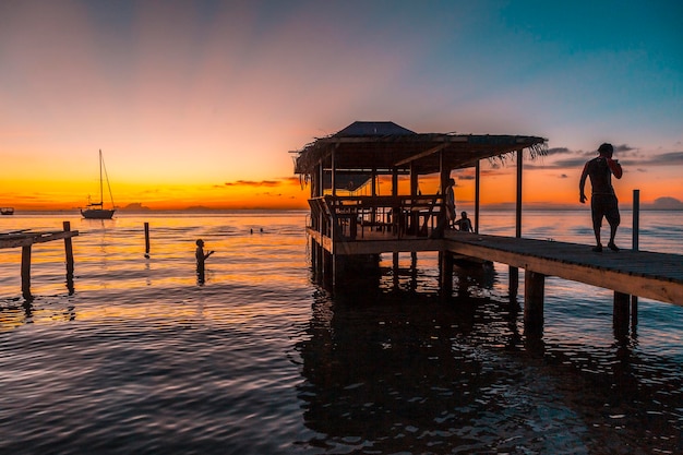 A pier and the boat in the background on a beach on Roatan Island Honduras