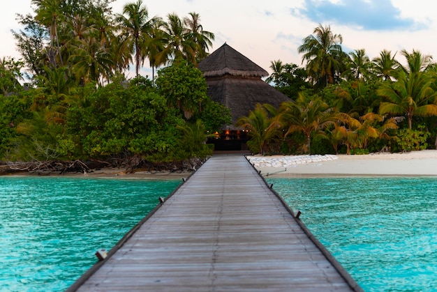 Pier leading to the island at sunrise in the Maldives the concept of luxury travel