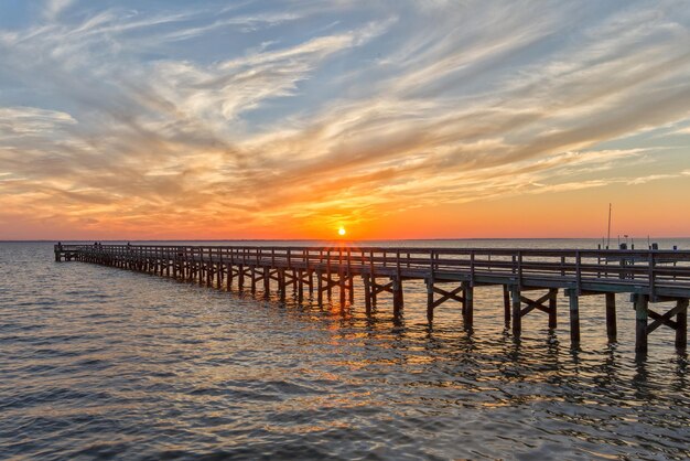 Photo pier over sea against sky during sunset