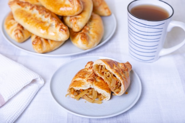 Pies (pirozhki) with cabbage. Homemade baking. Traditional Russian and Ukrainian cuisine.