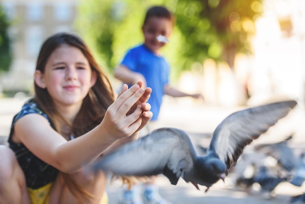 Pigeon flies out of the hands of a little girl Children play with pigeons