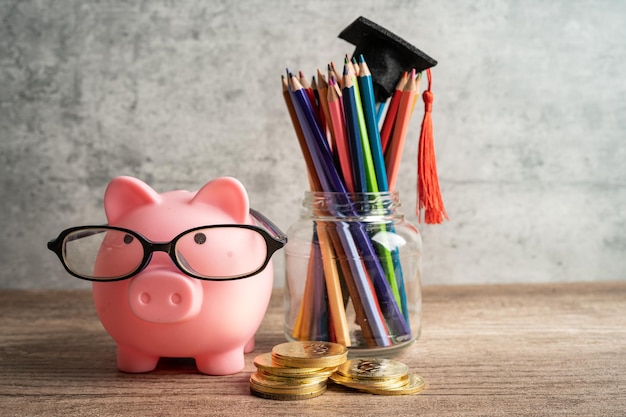 Pigging bank wearing eyeglass with colorful pencils saving bank education concept