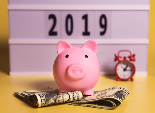 A piggy bank an alarm clock and the year 2019