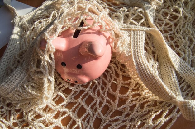 Piggy bank in the bag of a reusable shopping bag, the concept of zero waste, savings, savings, top view, close-up.