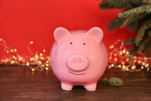 Piggy bank and blurred Christmas lights on background