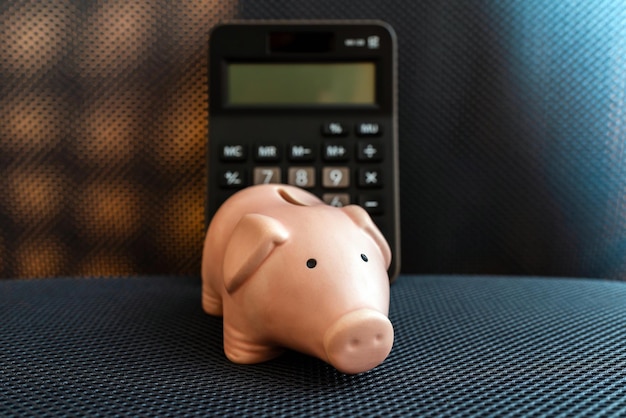 Piggy bank and calculator on grey surface backgroundCalculation of the family budget saving