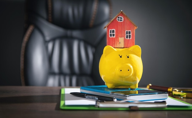 Piggy bank calculator and house model on the table