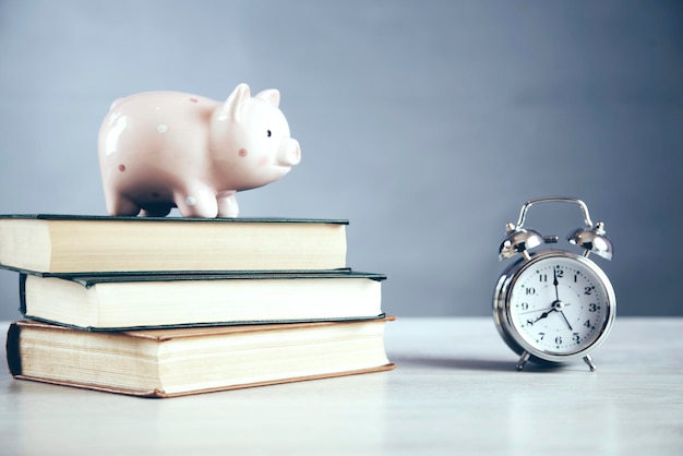 Piggy bank and clock on book