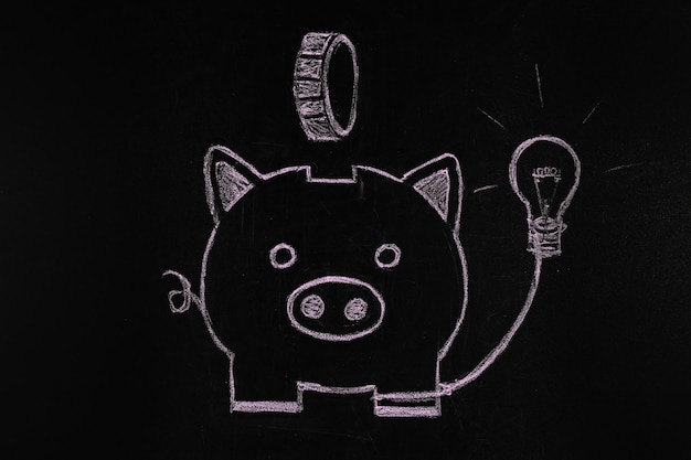 Photo piggy bank drawn with chalk on black background electricity price increasing concept