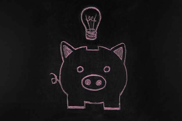 Photo piggy bank drawn with chalk on black background electricity price increasing concept