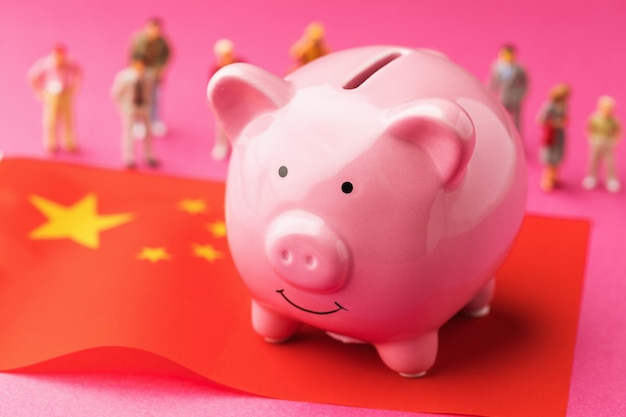 Piggy bank flag and plastic toy men concept on the theme of income of the population of China