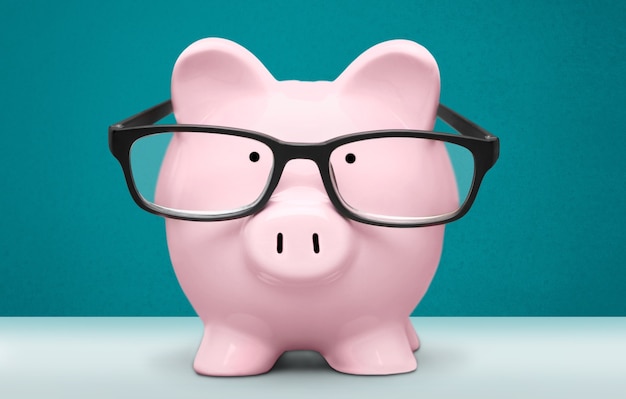 Photo piggy bank in glasses on background