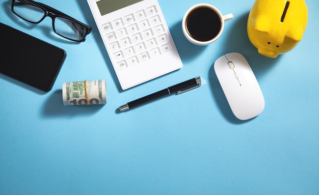 Piggy bank money coffee calculator eyeglasses on the blue background