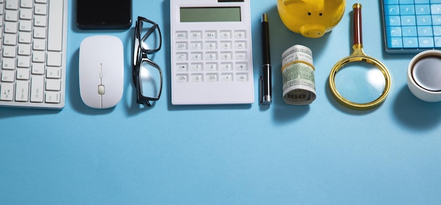 Piggy bank money coffee calculator eyeglasses on the blue background