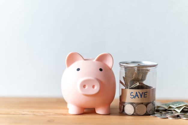 Photo piggy bank with coin on the wood table