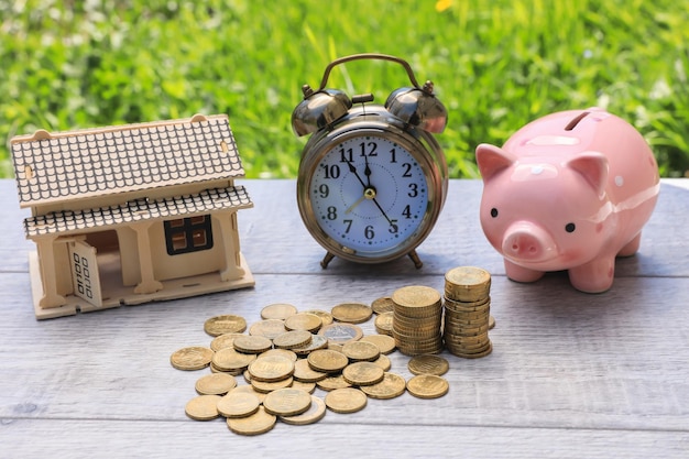 Piggy bank with coins and house model