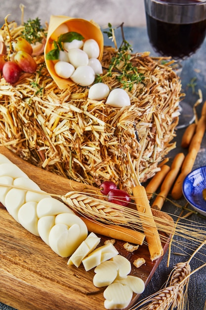 Pigtail-shaped mozzarella with grapes on a wooden background with bread ears