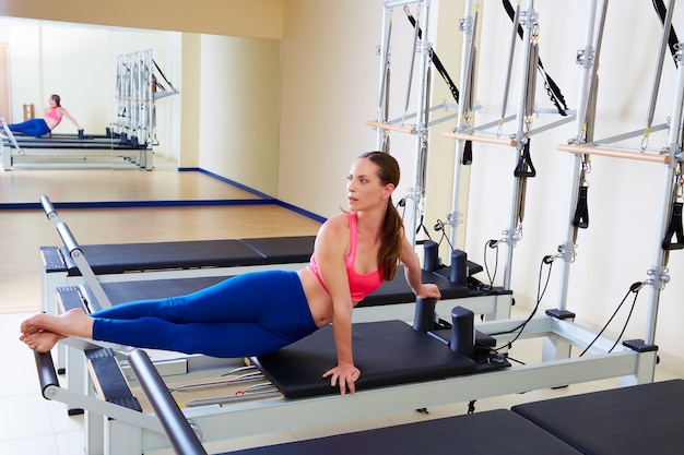 Pilates reformer woman snake twist exercise