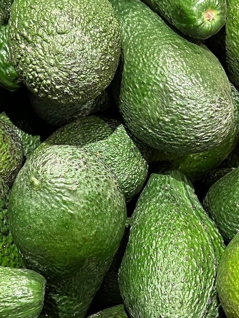 a pile of avocados with a lot of green avocados.