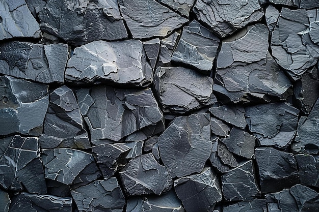 a pile of black rocks with a small white patch of snow on the top