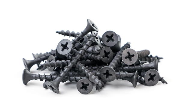 A pile of black self-tapping screws close-up on a white background. Isolated