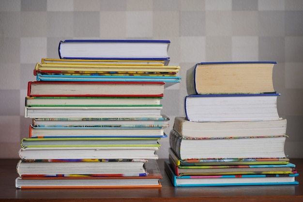 Pile of book on wooden table in mosaic brown background