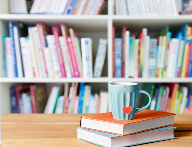 Pile of books with coffee cup on wooden table