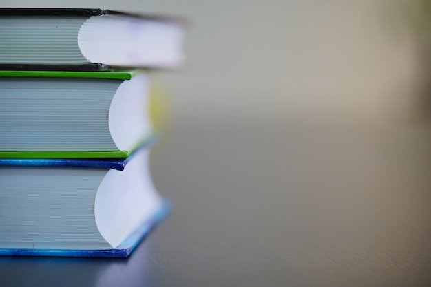 pile of books on wooden table with blur white background and space for text