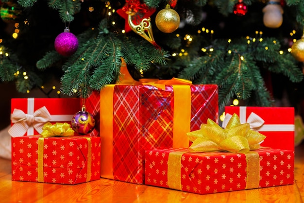 Pile of christmas gift boxes on the floor under beautiful christmas tree